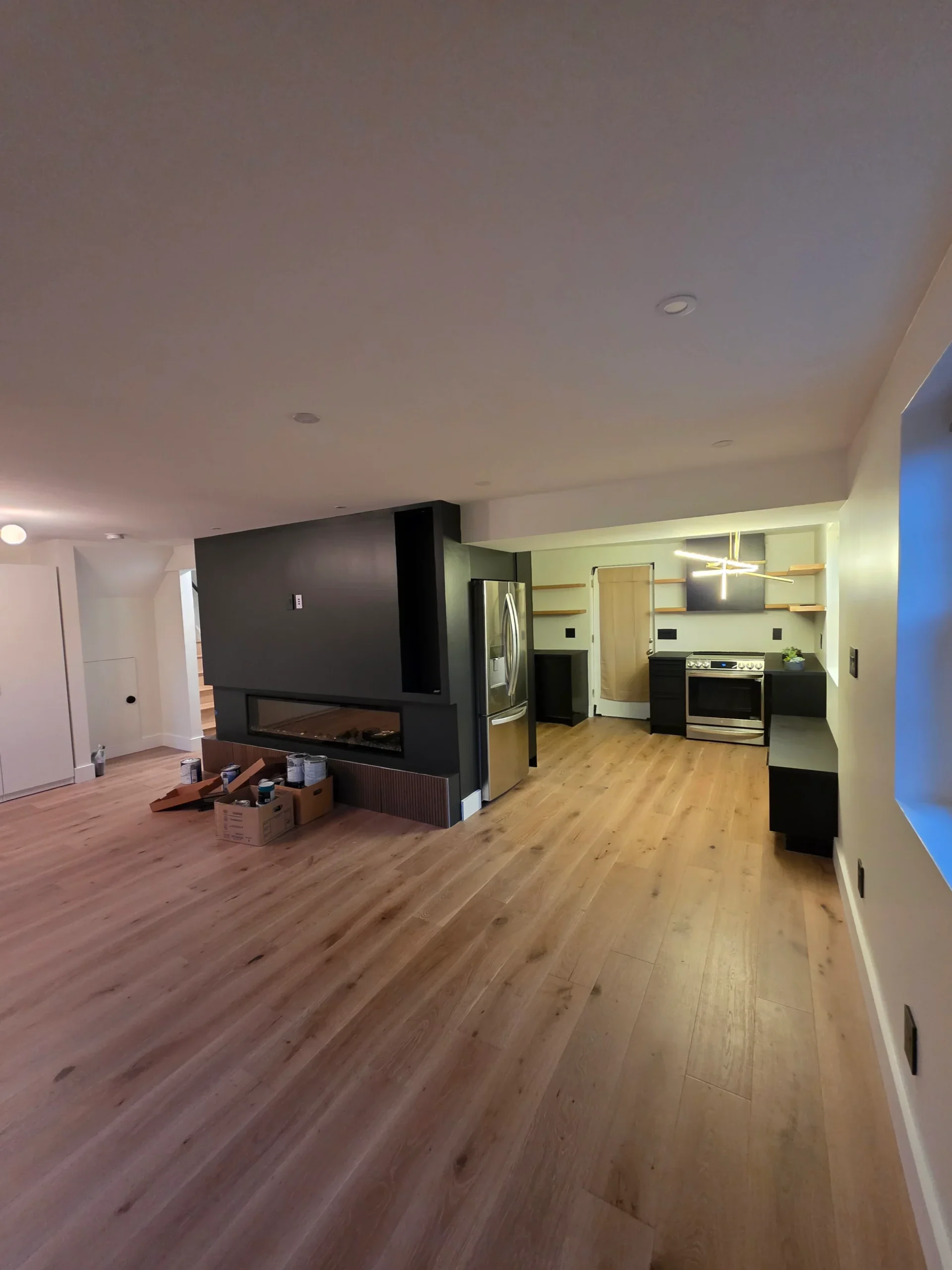 Finished hardwood flooring running through an open-plan living space