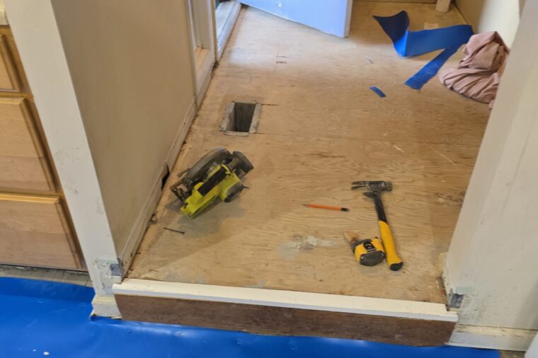 Plywood subfloor prepped with a moisture barrier before plank flooring is laid