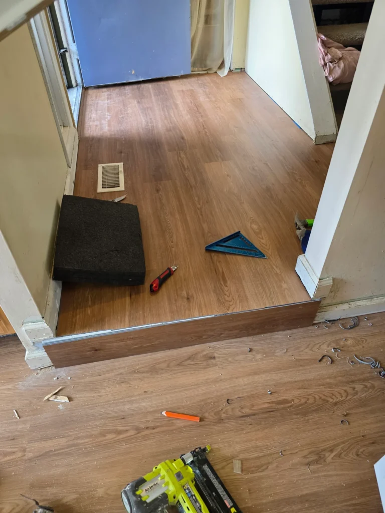 Full-length planks running down a hallway during installation