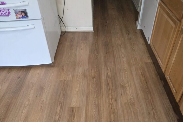 Finished luxury vinyl plank flooring running through a kitchen and hallway