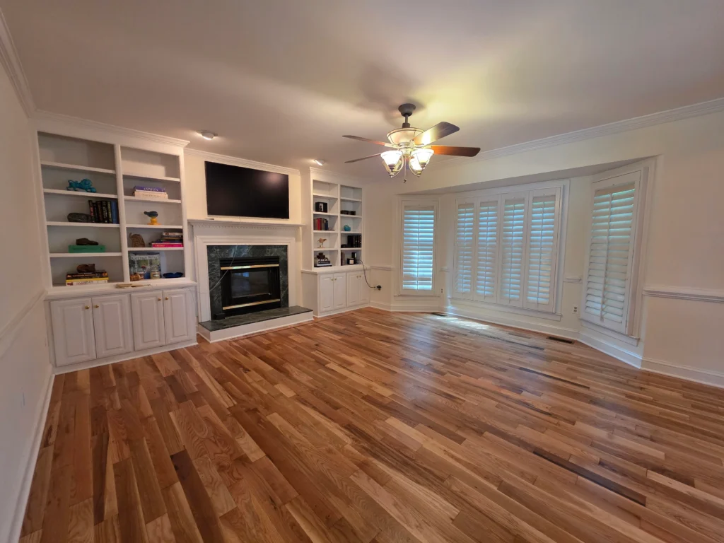Finished hardwood living room with built-in cabinetry and a fireplace