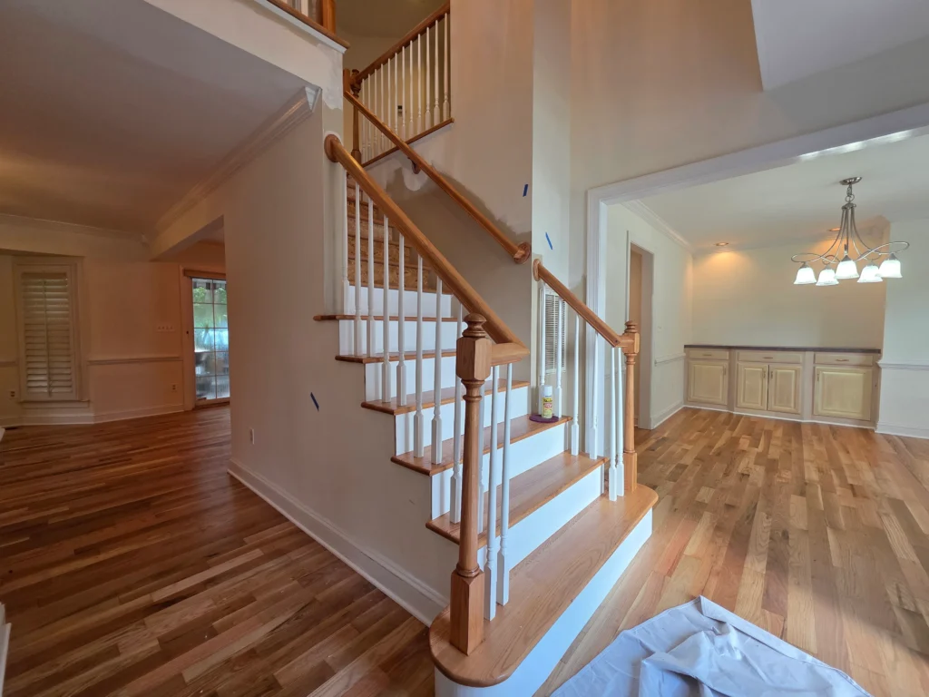Finished hardwood entry hall with the staircase and dining room beyond