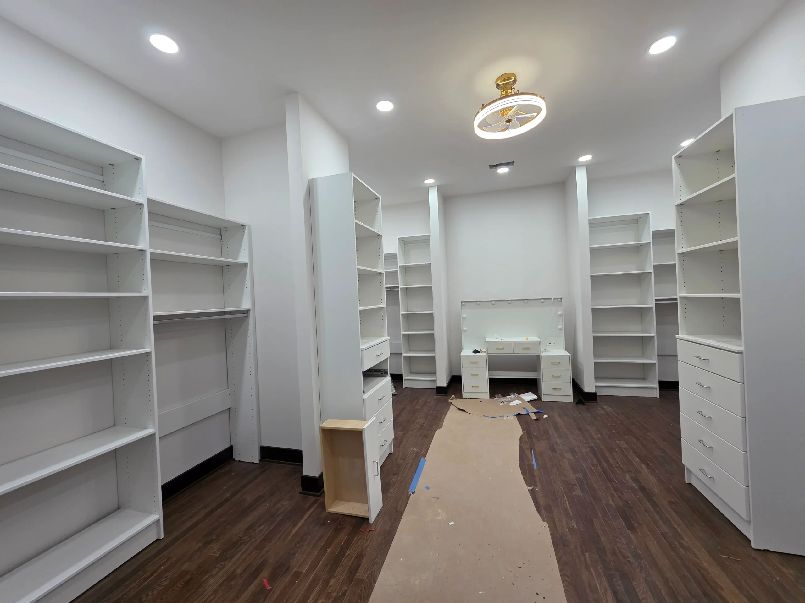 Finished dark hardwood floor in a room lined with built-in shelving