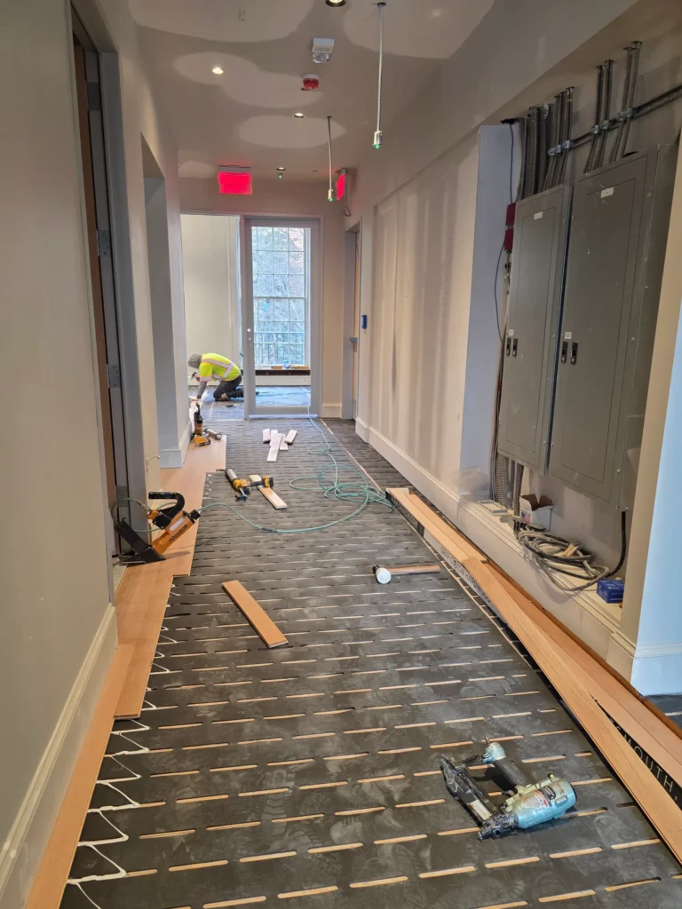 Laminate flooring cost calculator inputs in practice: materials staged along a measured hallway