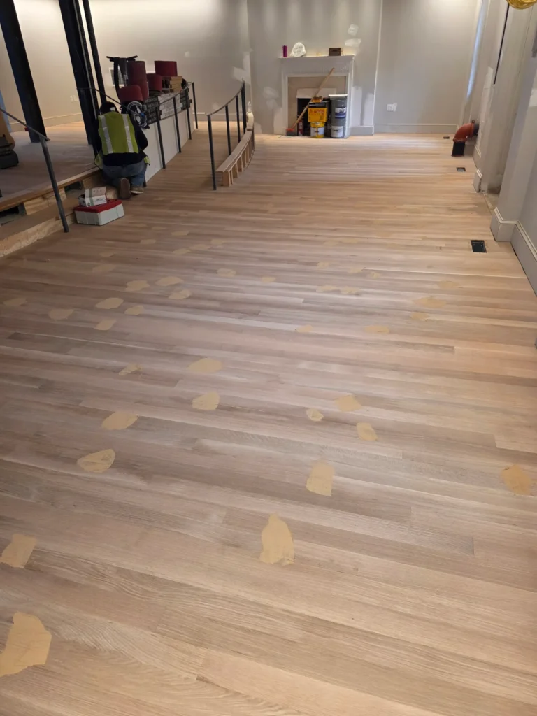 Finished light wide-plank flooring running the length of a room