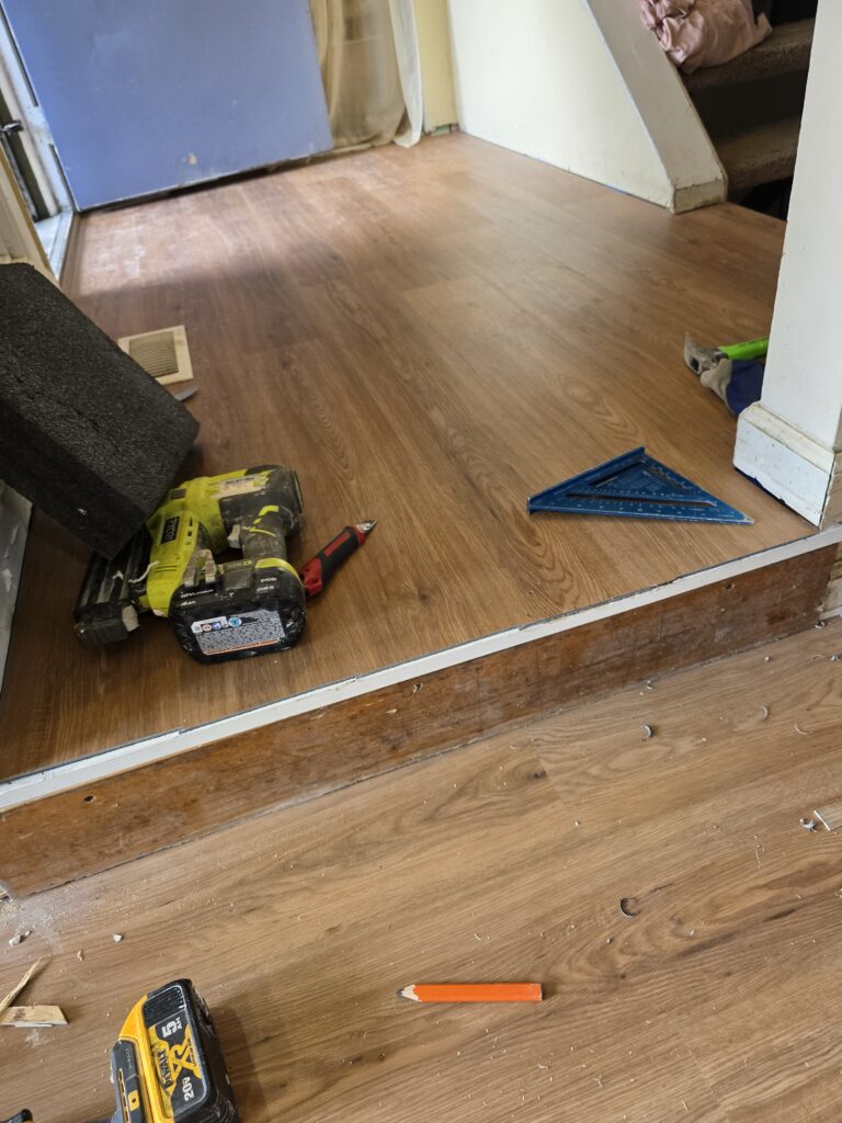 LVP flooring installation cost in practice: plank being fitted through a doorway