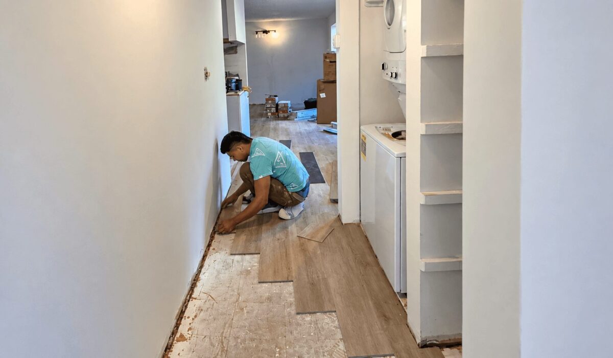 FIXO installer laying waterproof vinyl plank flooring in a DMV home