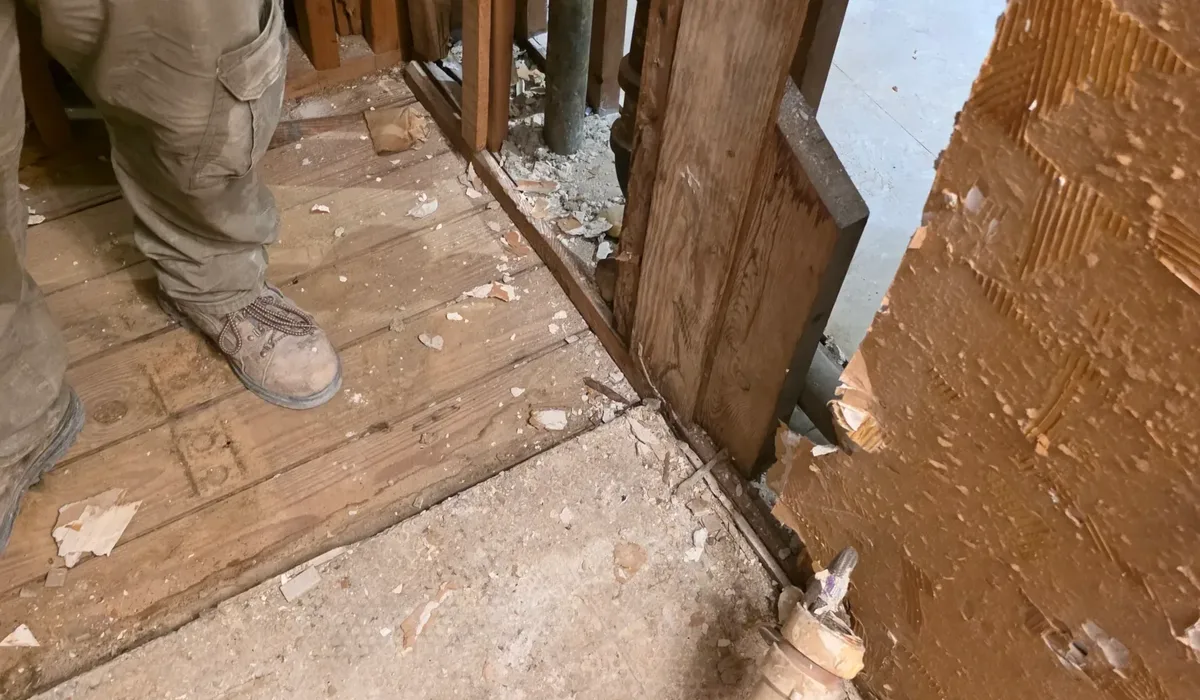Installer preparing a stripped bathroom floor before tile goes down