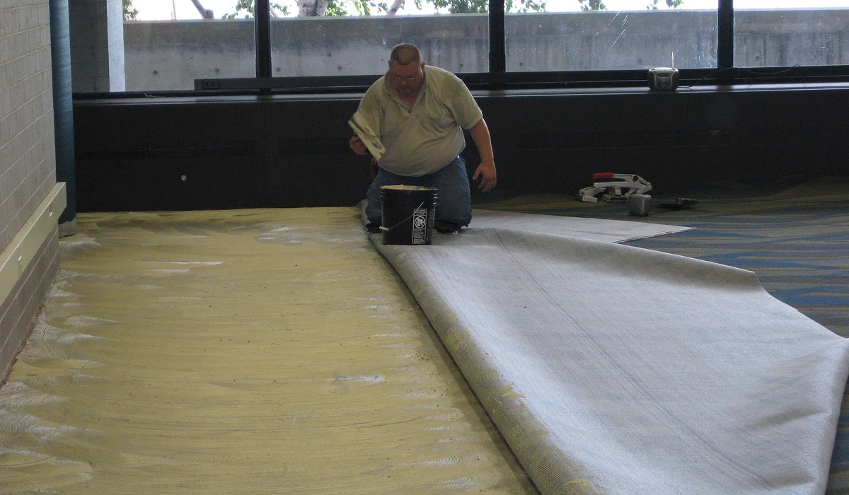 Carpet installers laying new carpet in a building