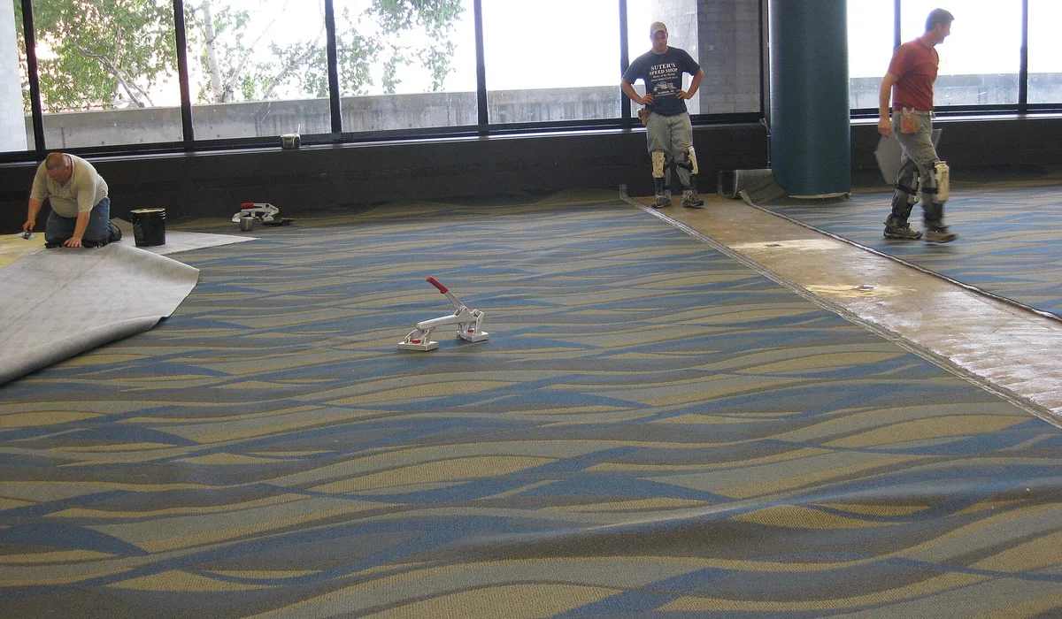 Carpet installers working on new wall-to-wall carpet