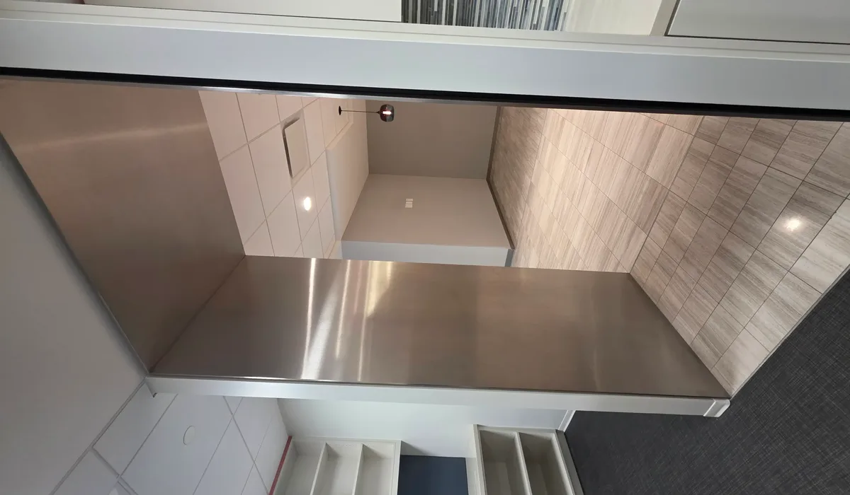 Commercial washroom with tiled walls and cubicle partitions