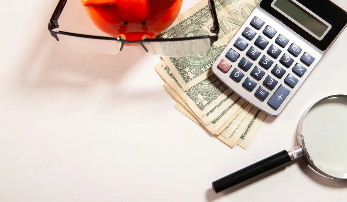 Calculator, cash and magnifying glass for comparing flooring bids