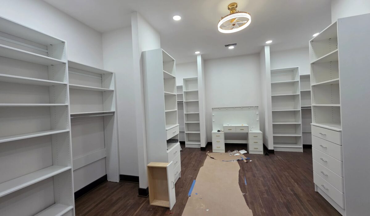 Dark hardwood floor finished in a room lined with built-in shelving