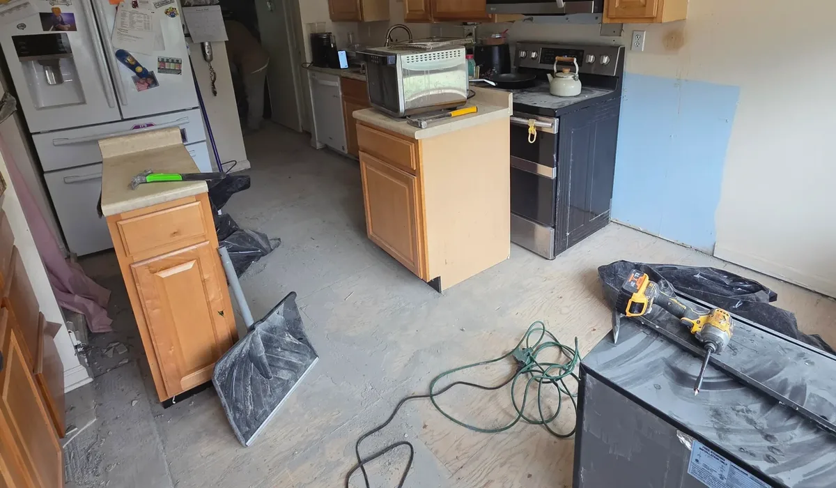 Kitchen with the old floor removed and the subfloor exposed for a flatness check