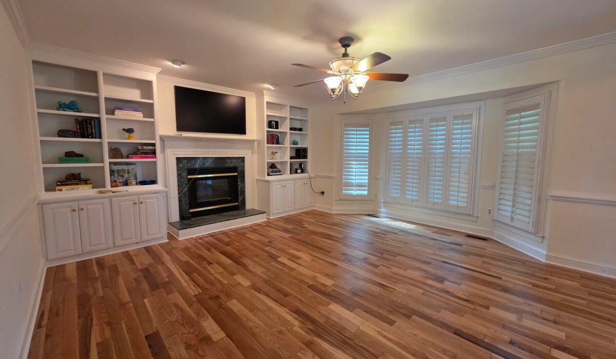 Hardwood floor installation in Alexandria VA homes often covers living rooms like this, with built-ins and a fireplace