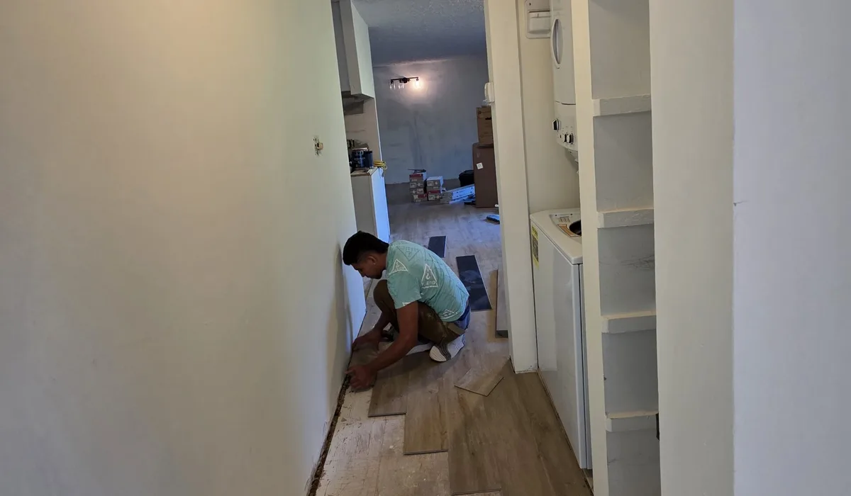 FIXO installer clicking luxury vinyl plank together along a hallway