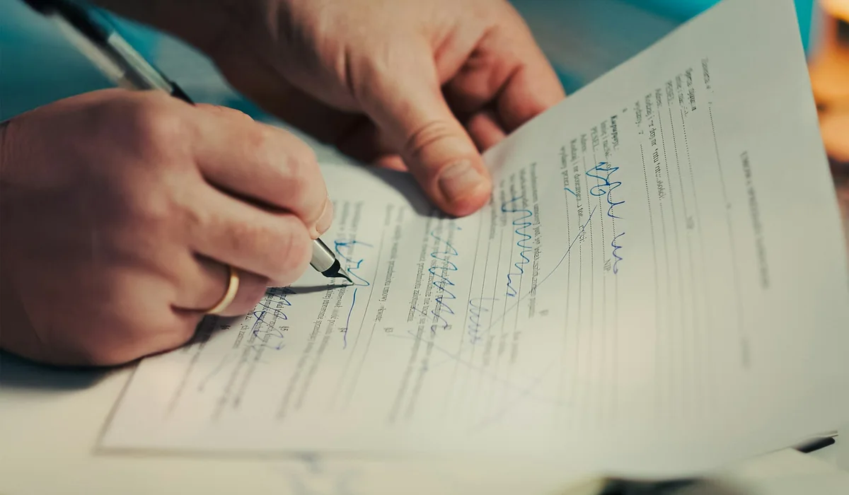 Homeowner signing a written contract with a laminate floor installation contractor