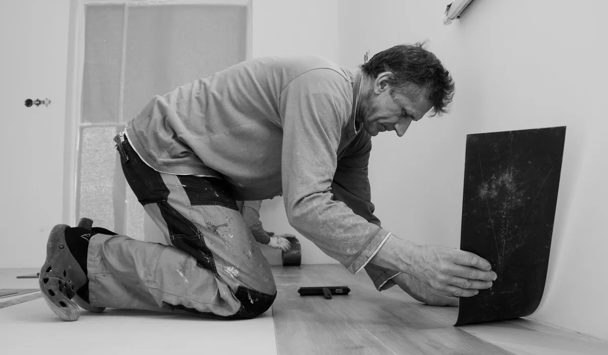 Installer angling a laminate plank into the click joint of the previous row