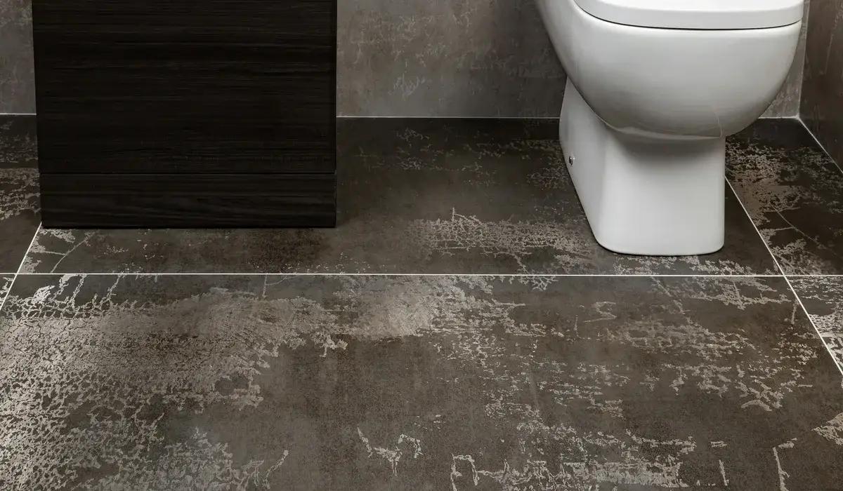 Large-format dark stone-look floor tile laid around a toilet in a modern bathroom