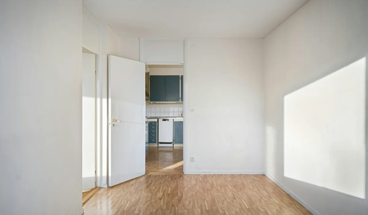 Empty room with white walls and a light plank floor, ready to measure for an LVP flooring installation cost calculator