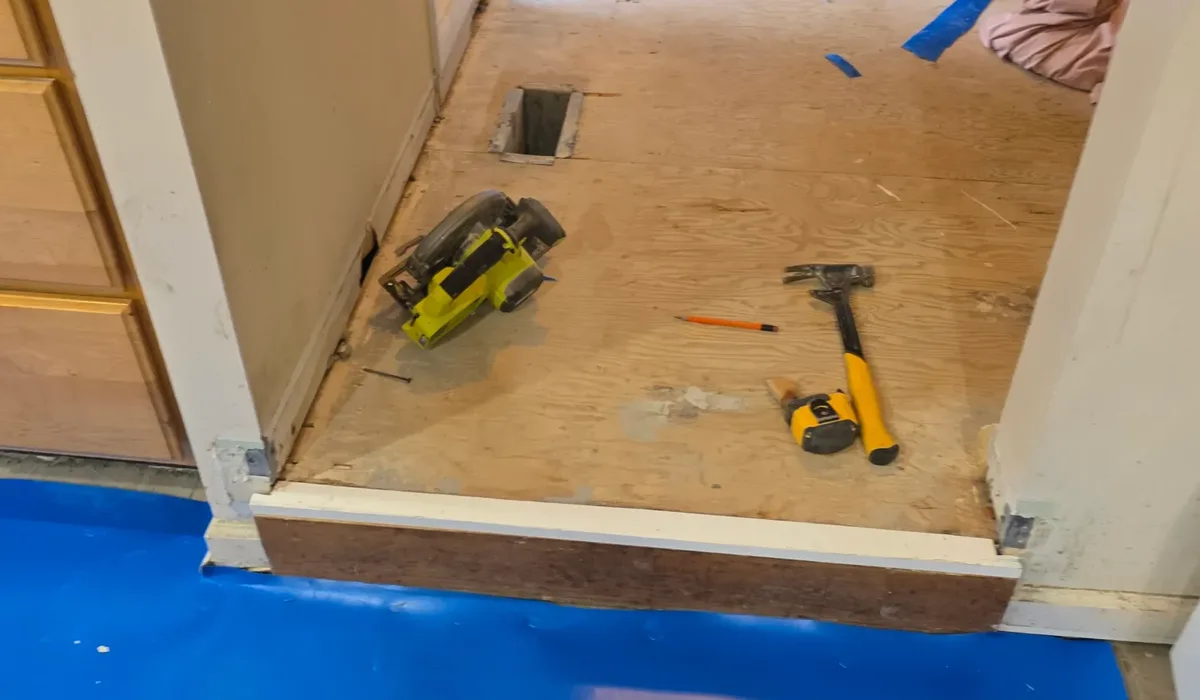 Blue moisture barrier rolled over a hallway subfloor before LVP planks go down