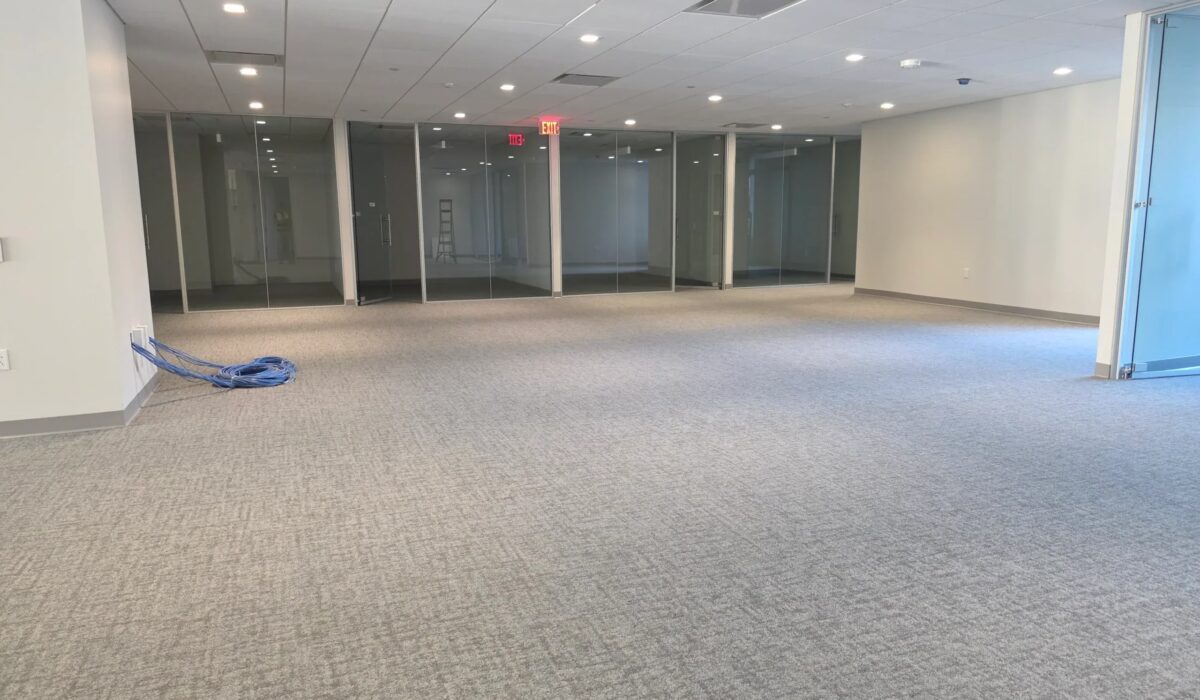 Open commercial floor plate laid with new light grey carpet tile