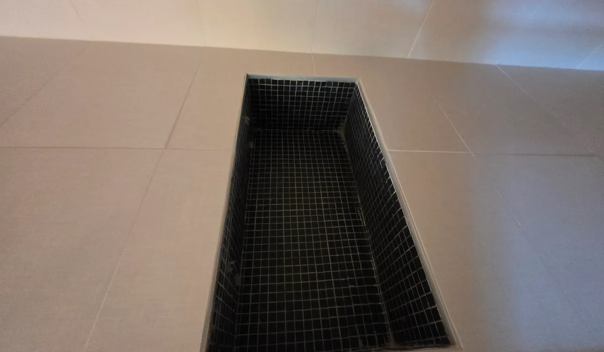 Northern Virginia waterproof flooring: large-format porcelain tile floor with a black mosaic shower pan