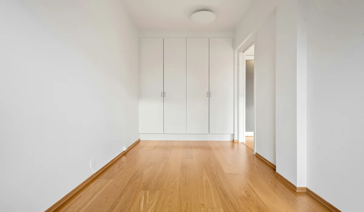 Open room with a wood floor and white walls, measured room by room for a flooring estimate