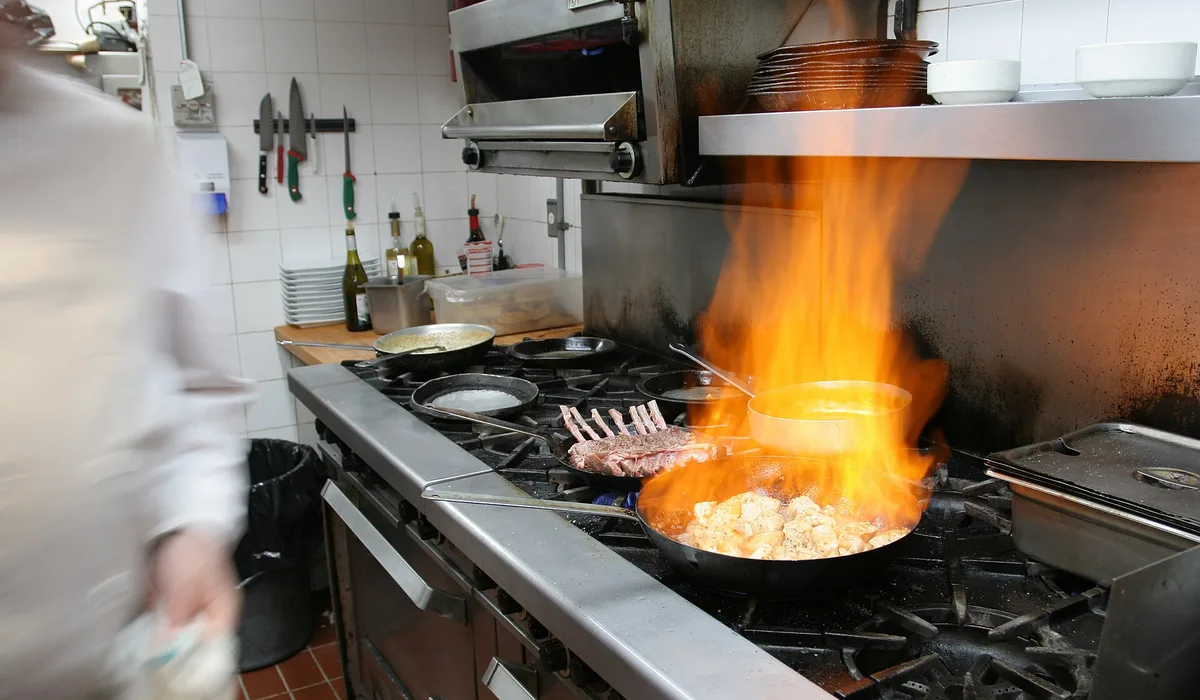 Busy restaurant kitchen line where floors face heat, grease and water