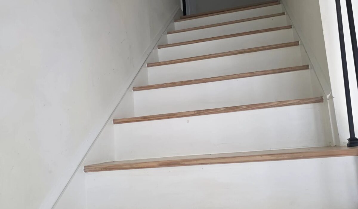 Painted stair treads and risers; loose or creaking treads are a common job for flooring repair contractors