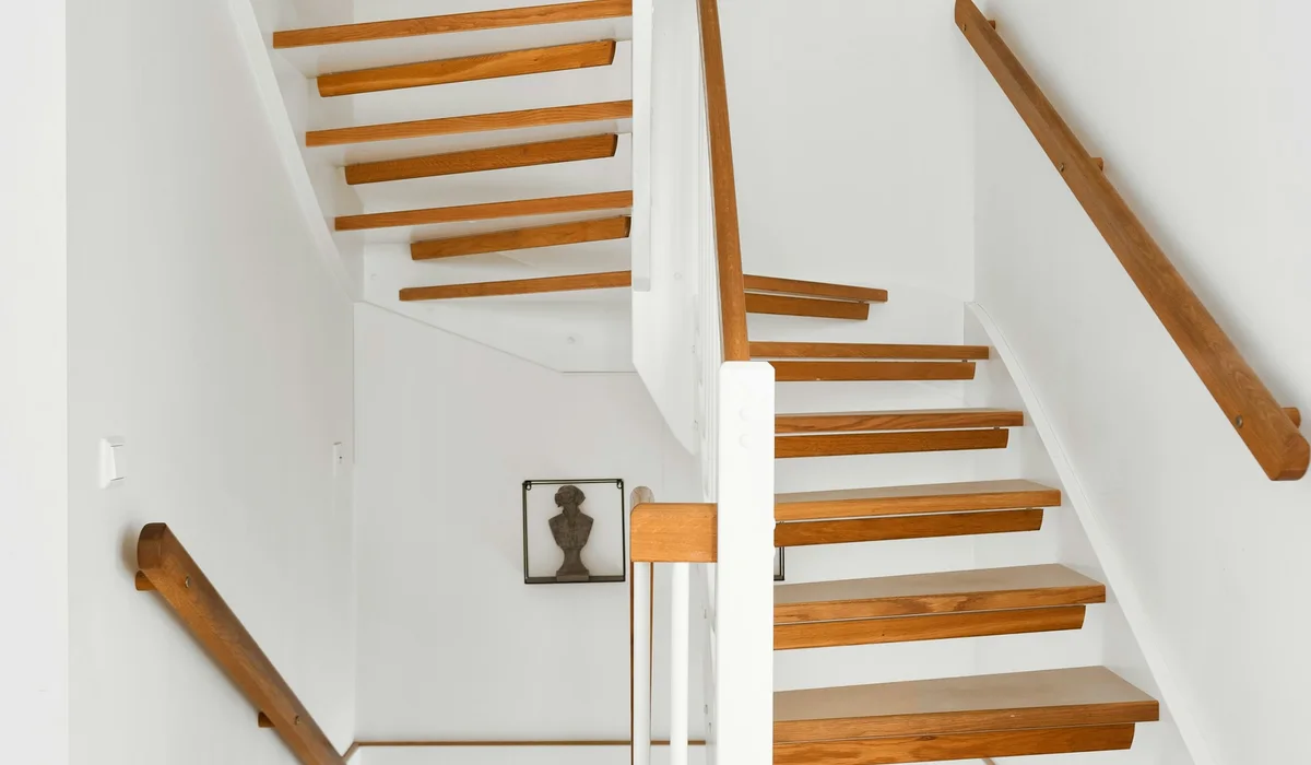 White staircase with wooden handrails in a home