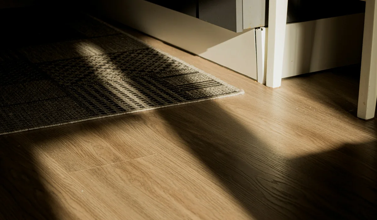 Strong sunlight falling across a hard floor near a window, a common cause of fading