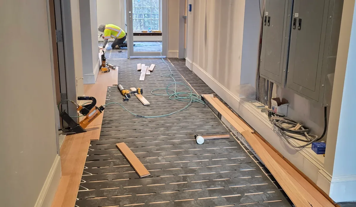 Boxes of vinyl flooring staged along a prepared hallway before installation