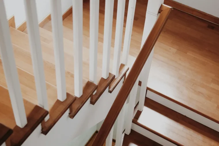 Wooden staircase with a white railing and handrail, a common style for wooden stair banister replacement in Virginia