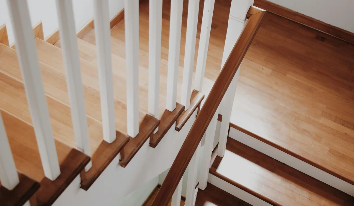 Wooden staircase with a white railing and handrail, a common style for wooden stair banister replacement in Virginia
